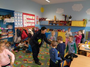 policjantka z wizytą w szkole rozdaje dzieciom odblaski