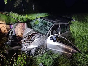 Pora nocna. Rozbite auto osobowe stojące na poboczu w trawie.