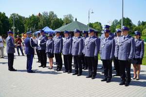 Dwa szeregi policjantów, przed nimi komendant Wojewódzki Policji w Olsztynie wręczający akt mianowania na wyższy stopień służbowy.