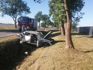 Pojazd Audi znajdujący się w przydrożnym rowie a w tle wóz straży pożarnej