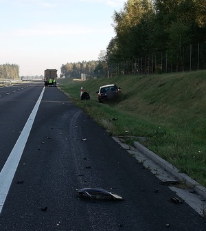 Pas drogi S7 po prawej stronie w rowie pojazd osobowy uczestniczący w zdarzeniu drogowym a w oddali pojazd ciężarowy