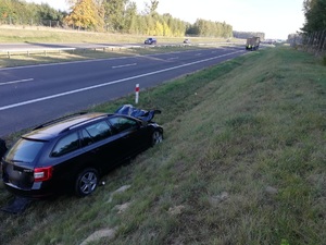 stojący w przydrożnym rowie pojazd osobowy z rozbitym przodem a w tle trasa s7