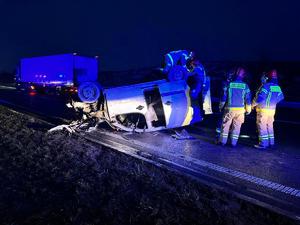 Miejsce zdarzenia drogowego na drodze ekspresowej S7. Zmrok. Na drodze na dachu leży pojazd osobowy , wokół stoją stażacy i inne samochody.