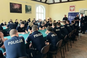 Świetlica. Policjanci siedzący przy stołach w trakcie odprawy.