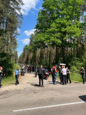 Droga leśna. Na niej kilkadziesiąt osób.