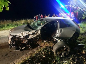 Pora nocna. Pojazd uczestniczący w kolizji drogowej w m. Kuce. Auto osobowe marki renault z rozbitym przodem i lewym bokiem, obok auta leży urwane koło.
