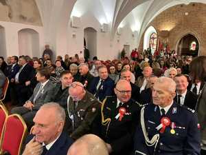 Uczestniczy uroczystości siedzący na przestronnej sali.