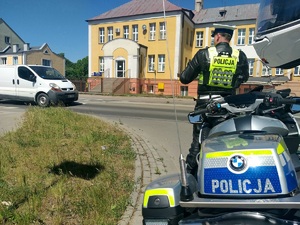 Policjant ruchu drogowego w trakcie pomiaru prędkości.