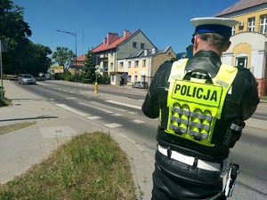 Policjant ruchu drogowego w trakcie pomiaru prędkości jazdy.