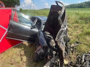 Miejsce wypadku drogowego ze skutkiem śmiertelnym. Auto rozbite na skutek zderzenia znajdujące się na trawie poza droga.