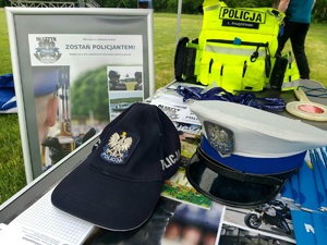 Czapka policjanta ruchu drogowego, ulotki i plakat dot. doboru do służby w Policji.