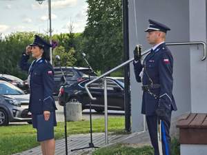 Policjant i policjantka w trakcie śpiewania Hymnu Państwowego