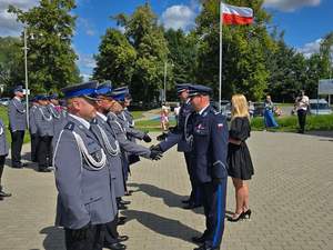 Zastępca Komendanta Wojewódzkiego wręcza policjantom akty mianowania.