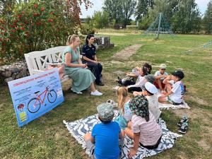 Policjantka, przedstawicielka Sanepidu i grupa kilkorga dzieci.