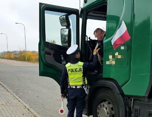 Policjant podczas kontroli drogowej ciężarówki.