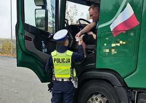 Policjant podczas kontroli drogowej ciężarówki.