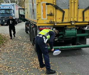 Policjant podczas kontroli drogowej ciężarówki.