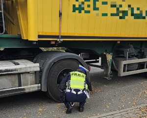 Policjant podczas kontroli drogowej ciężarówki.