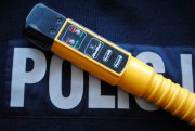 na tle napisu policja położony jest urządzenie do badania stanu trzeźwości Alcoblow