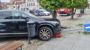 Miejsce zdarzenia drogowego w centrum Nidzicy. Rozbite auto czarny suv.