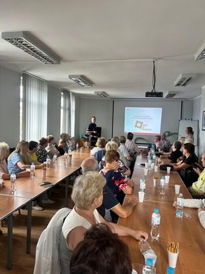 Seniorzy słuchający prelekcji policjanta