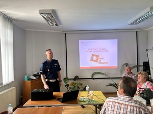 Seniorzy słuchający prelekcji policjanta