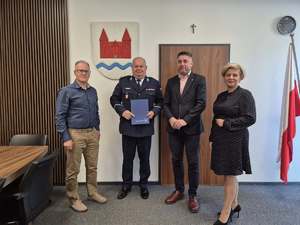 Policjant i 3 osoby siedzące przy stole