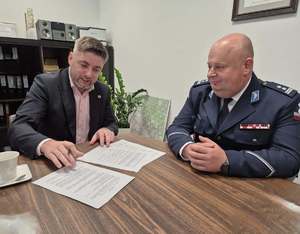 Policjant i 3 osoby siedzące przy stole