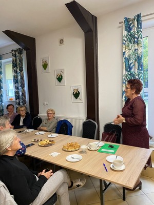 Spotkanie z seniorami. Prelegent i siedząca grupa seniorów.
