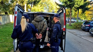 policjanci prowadzą zatrzymanego