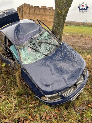 Rozbite o drzewo auto osobowe. W tle stóg siana.