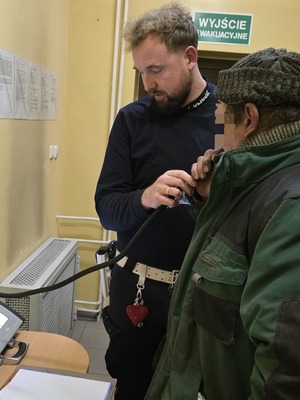 policjant w trakcie wykonywania badania stanu trzeźwości