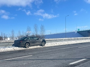 Auto stojące na zasypanym śniegiem poboczu drogi.
