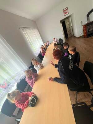 Policjantka siedzi przy stole z grupą dzieci