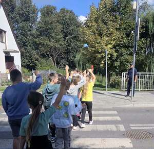Z dzielnicowym „Razem przechodzimy przez pasy” - policjant z dziećmi w okolicy przejścia dla pieszych